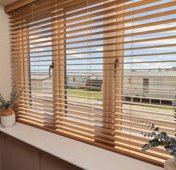 A window with blinds and plants on the sill at Craster House in Seahouses