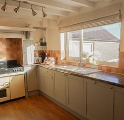 A kitchen with a stove and sink at Rhianfa Newborough