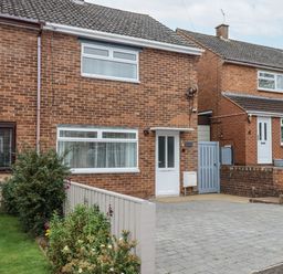 A brick house with a driveway and garden at Milana in Tiverton