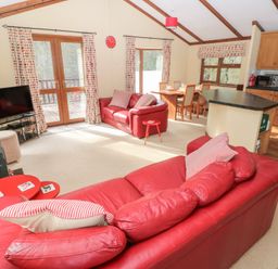 A living room with a sofa and television at Riverside Lodge 3 