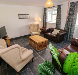 A living room with sofas and a coffee table at Coach House Cottage 