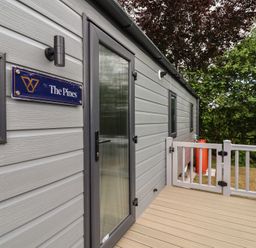 An entrance with door and sign at The Pines 2 Bedrooms in Delamere