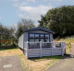 A mobile home with a deck and steps outside at The Pines 2 Bedrooms Delamere