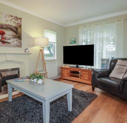 A living room with a sofa, coffee table, and television at Lodge 9 - Lamorna in Tregolds near St Merryn