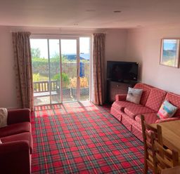 A living room with a sofa and dining table at 1 Penrose Court in Penzance