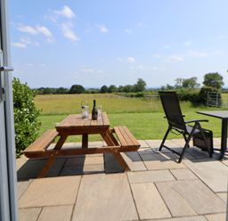 An outdoor seating area with a table and chairs at Honeypot Hideaways - Acacia