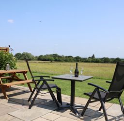 An outdoor seating area with chairs and a table at Honeypot Hideaways - Acacia