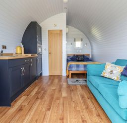A living room with a kitchen and a bed at Honeypot Hideaways - Acacia