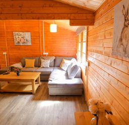 A living room with a sofa and coffee table at Stumps Cross Lodge in Upper Coscombe near Winchcombe