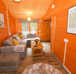 A living room with a sofa and coffee table at Stumps Cross Lodge in Upper Coscombe near Winchcombe