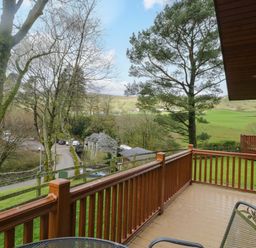 A view of trees and a road from a deck at Wansfell 2 Limefitt Park near Troutbeck