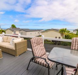An outdoor seating area with sofa and table at Ty Seren in New Quay