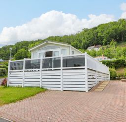 A house with a white fence and a pathway at Ty Seren in New Quay