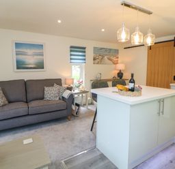 A living room with a sofa and kitchen island at Stoney Rock Lodge 