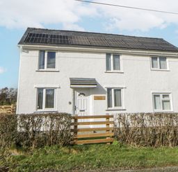 A house with solar panels and a fence at Glandwr House in Crossgates near Llandrindod Wells