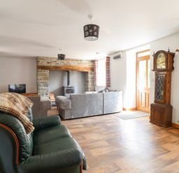 A living room with an armchair and sofa at Gwernffridd