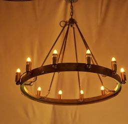 A circular metal chandelier with multiple small lights hanging from the ceiling at Russet Lodge in Glastonbury