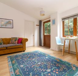 A living room with a sofa and a dining table at The Cow Shed in 