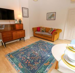 A living room with a sofa and television at The Cow Shed 