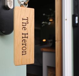 A wooden key tag with The Heron hanging on a door lock at The Heron in Lode near Bottisham