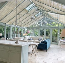 A conservatory with a kitchen island and seating area at Trenare in Truro