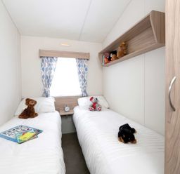 A bedroom with twin beds and stuffed animals at Mariner's Meadow - Hayling Island