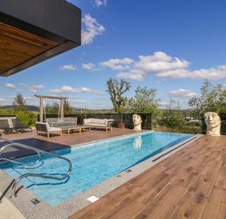 An outdoor area with a swimming pool and seating at Forest Lodge in Pontyclun