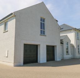 An exterior view of a house with garage doors at The East Wing Apartment in Claremorris