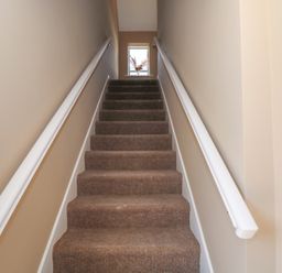 A staircase with carpet and a window at The East Wing Apartment in Claremorris