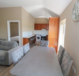A living room area with a sofa and dining table at The East Wing Apartment in Claremorris