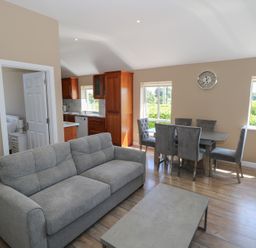 A living room with a sofa and dining area at The East Wing Apartment in Claremorris