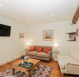 A living room with a television and sofa at Stable cottage Sopworth near Sherston