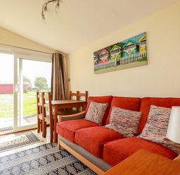 A living room with a sofa and dining table at 101 Atlantic Bays Holiday Park in Padstow