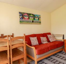 A living room with a sofa and dining table at 101 Atlantic Bays Holiday Park in Padstow