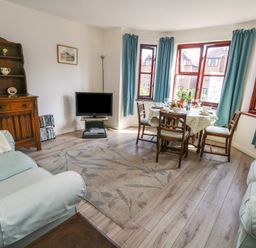 A living room with a dining area and television at Flat 9 in Swanage