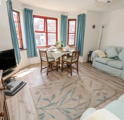 A living room with a table set for dining at Flat 9 in Swanage