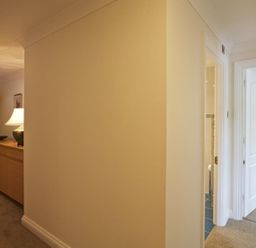 A hallway with a wooden cabinet lamp and coat stand and doors leading to other rooms at 10 Dartmouth House in Dartmouth