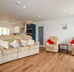 A living room with a sofa and armchairs at Folly View in Cambrose near Illogan