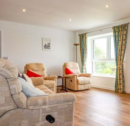 A living room with armchairs and a table at Folly View Cambrose near Illogan