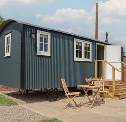 A shepherd's hut with a table and chairs at Shepherd's Hut in Wrexham