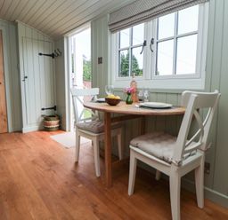 A dining room with a table and chairs at Shepherd's Hut in Wrexham