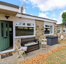 An outdoor seating area with a bench and chairs at No 157 Sandown Bay Holiday Chalet 'Field View' Sandown