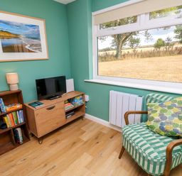 A living room with a tv and books at No 157 Sandown Bay Holiday Chalet 'Field View' Sandown