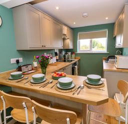 A kitchen with a dining table set for four at No 157 Sandown Bay Holiday Chalet 'Field View' Sandown