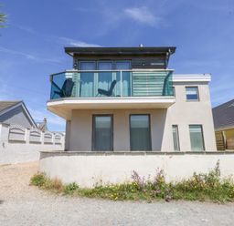 A house with a balcony and windows at Shearwater in Rhosneigr