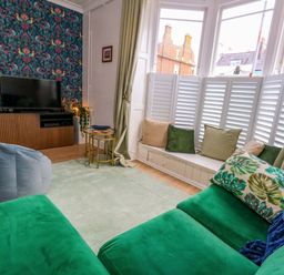 A living room with a television and bookshelf at Seagull & Chips in Weymouth