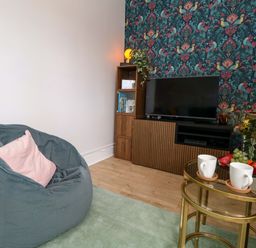 A living room with a bean bag and tv stand at Seagull & Chips in Weymouth
