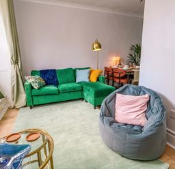 A living room with a green sofa and bean bag at Seagull & Chips in Weymouth