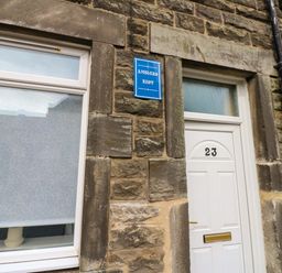 A white door and window with a nameplate at Amblers Rest in Amble