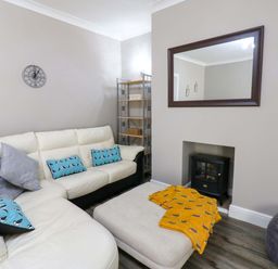A living room with a sofa and shelf at Amblers Rest in Amble